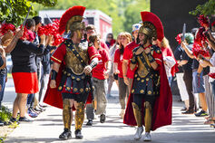 Two students dressed in Titan mascot outfits walk on campus.